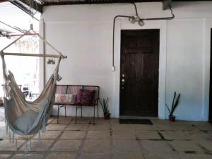 une chambre avec un hamac devant une porte dans l'établissement Hogar tico-estadounidense cerca de aeropuerto, à Alajuela