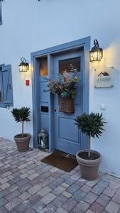 una puerta azul con dos macetas delante de un edificio en La Esencia, en Ríocorvo