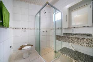 W łazience znajduje się toaleta i przeszklony prysznic. w obiekcie Sobrado Frente ao Mar Mariscal 6 Pessoas w mieście Bombinhas