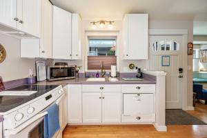 uma cozinha com armários brancos e uma bancada em Hanna's House by WanderLodges em Ashland