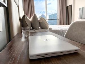 einen Laptop auf einem Holztisch in einem Hotelzimmer in der Unterkunft The Capital in Sandton-Luxury aparthotel in Johannesburg