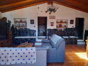 a living room with a blue couch and a table at Casa La Gollada in Cazadores