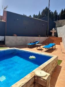 Cazadores的住宿－卡薩拉格拉達酒店，一个带2把蓝色椅子和桌子的游泳池