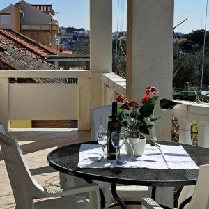 una mesa con una botella de vino y dos copas en Apartments Vrsi Bay en Vrsi