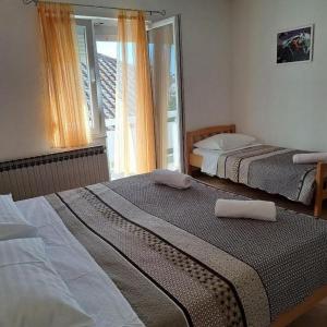 2 camas en una habitación con ventana en Apartments Vrsi Bay en Vrsi