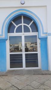 a blue and white building with a large window at شقة لقضاء عطلة مميزة بمدينة الفنيدق in Riffiene