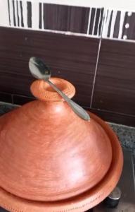 a spoon sitting on top of a brown plate at شقة لقضاء عطلة مميزة بمدينة الفنيدق in Riffiene