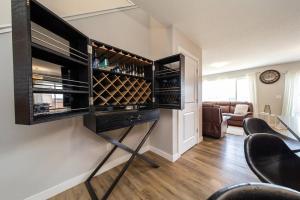 um quarto com um bar com garrafas de vinho na parede em 3BDRM Home, 5min to WEM/4min to River Cree Casino em Edmonton
