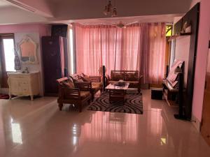 Nice Luxury Suites في راجشاهي: غرفة معيشة مع أريكة وكراسي وطاولة