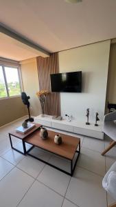 Cobertura,conforto e localização في خوازيرو دو نورتي: غرفة معيشة مع طاولة قهوة وتلفزيون