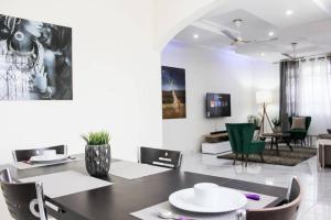 comedor y sala de estar con mesa y sillas en Kojosvilla Luxury Homes, en Kwedonu