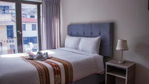 a bedroom with a large bed and a window at Esmeralda Suite in Cusco