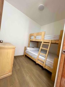 1 Schlafzimmer mit 2 Etagenbetten und Holzboden in der Unterkunft Viamar Chincha® Casa de Playa con Piscina 1er fila in Sunampe