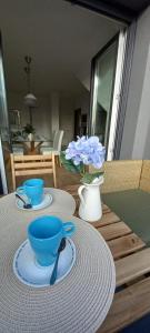 希洪的住宿－EL ENCANTO CON VISTAS PARKING PRIVADO，一张桌子,上面有两个蓝色的碗和一个花瓶