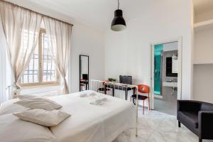 um quarto branco com uma cama e uma secretária em Locanderia Roma em Roma