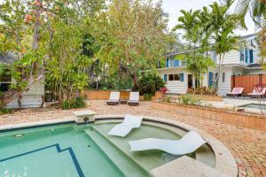 a swimming pool with two white chairs in a yard at Lush West Palm Beach Getaway with Backyard Oasis! in West Palm Beach