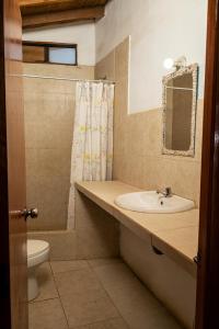 ein Badezimmer mit einem Waschbecken, einem WC und einem Spiegel in der Unterkunft LA PUNTA LOBITOS HOTEL in Talara
