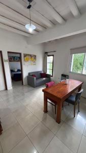 sala de estar con mesa de madera y sofá en Tierras del Malbec 1 en Luján de Cuyo