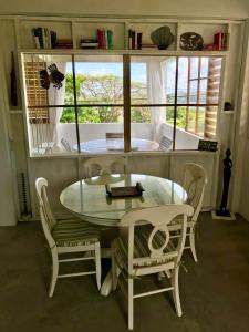Una mesa y sillas en una habitación con ventana. en Antigua Blue, en Liberta