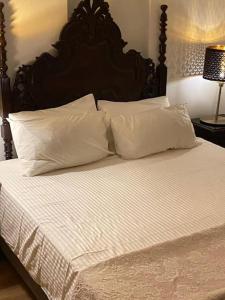 a bed with white sheets and pillows on it at The Blue House in Olhão