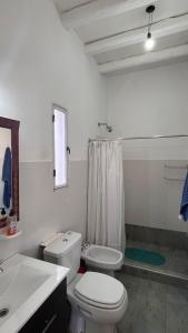 Baño blanco con aseo y lavamanos en Tierras del Malbec 1 en Luján de Cuyo