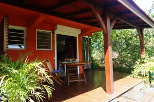 an orange house with a wooden deck with a table at Caraibe Créol' Keys in Port-Louis