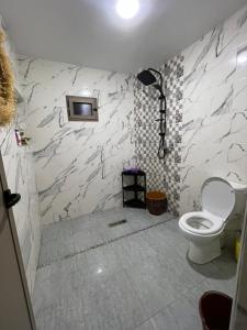 a bathroom with a toilet and a tv on the wall at شقة تتوفر على جميع شروط الراحة و الامان in Benguerir