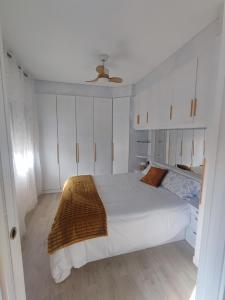 a bedroom with a white bed and a ceiling fan at Apartamento Figueres Plaza Cataluña in Figueres