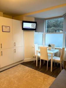 a dining room with a table and a tv on a wall at Cardiff/Penarth Home in Cardiff