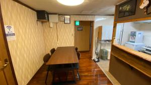 una habitación con mesa y sillas en un restaurante en Okinawa Naha JinJin -沖縄伝統体験型宿じんじん- en Naha