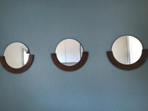 3 Spiegel an einer blauen Wand in einem Raum in der Unterkunft T2 Miami Beach in Narbonne-Plage