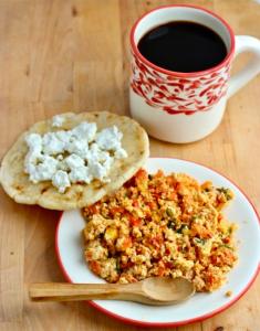 a plate of food with a spoon and a cup of coffee at Aldea Sabatinga in Manizales