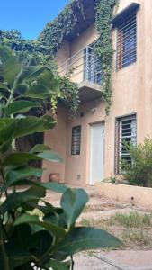 a building with a white door and some plants at Tierras del Malbec 2 in Ciudad Lujan de Cuyo