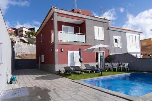 a villa with a swimming pool and a house at Villa Costa in Santa Cruz de Tenerife