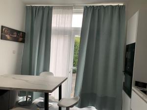 mesa y sillas en una habitación con ventana en Appartement séparé avec parking dans villa, en Vilvoorde