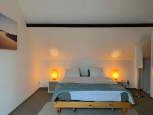 1 dormitorio con 1 cama grande y 2 lámparas en Appartement séparé avec parking dans villa, en Vilvoorde