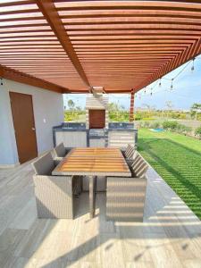 un patio con mesa y sillas bajo un techo en Imperia Chincha® Casa de Playa y Campo con Piscina, en San Pablo