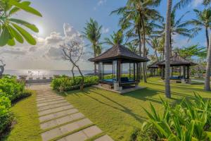 a garden with a gazebo and the ocean at Conrad Bali in Nusa Dua