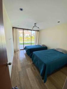 1 dormitorio con 2 camas y ventana en Imperia Chincha® Casa de Playa y Campo con Piscina, en San Pablo