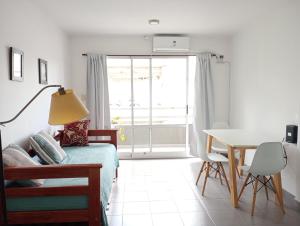 1 dormitorio con cama, mesa y ventana en Hogareño departamento calle 42 en La Plata