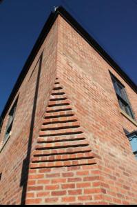 een hoge stenen toren met een ladder erop bij No.1 Clement House in York