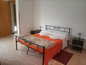 een slaapkamer met een bed met een oranje deken bij CASA D'ALUNZIO - CASE PER FERIE IN OSPITALITA' DIFFUSA in San Marco dʼAlunzio