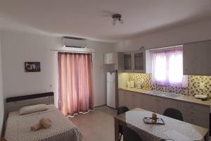 una cocina con mesa y mesa y una cocina con mesa en Larinaki's Cozy Apartment No1, en Órmos Aiyialís