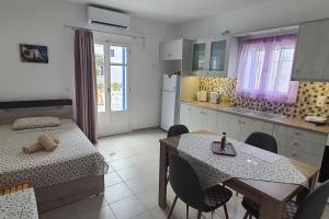 cocina y comedor con mesa, mesa y sillas en Larinaki's Cozy Apartment No1, en Órmos Aiyialís