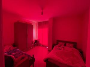 a red room with two beds and a red light at B&B - Private Rooms in Tirana