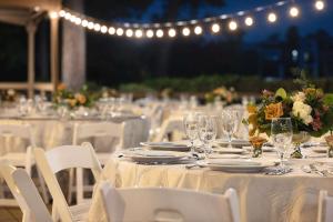 un groupe de tables avec des verres, des fleurs et des lumières dans l'établissement The Woodlands Resort, Curio Collection by Hilton, à The Woodlands