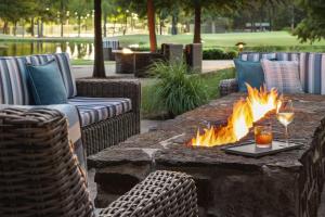 a fire pit with a glass of wine and a glass of wine at The Woodlands Resort, Curio Collection by Hilton in The Woodlands +139 photos