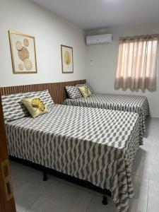 twee bedden in een hotelkamer met rokken bij Bela Beach in São José da Coroa Grande