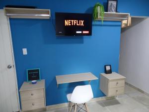 an office with a blue wall and a desk and a chair at Apartamento en el sur de Cali in Cali