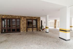 une pièce vide avec un mur et des portes en pierre dans l'établissement Aconchegante apartamento próx da praia BFC204, à Cabo Frio
